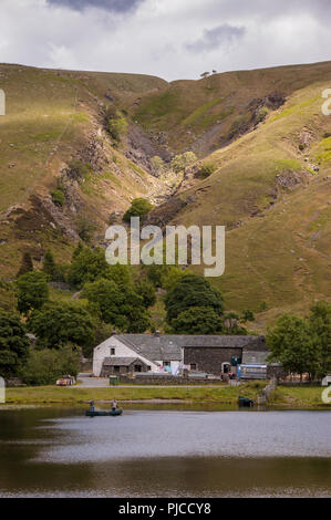 Keswick, England, Regno Unito - 20 Giugno 2008: una coppia di pescatori pesca da una piccola barca a remi su Watendlath Tarn lago sotto le montagne di Inghilterra del Lago Foto Stock