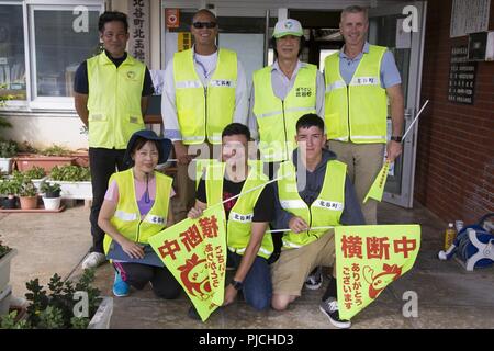 CHATAN TOWN, Okinawa, in Giappone- Marines e i membri della comunità locale posano per una foto al Kitatama centro comunitario Il 19 di luglio nella città di Chatan, Okinawa, in Giappone. Il gruppo si è offerta volontariamente come un incrocio guard per aiutare la scuola elementare di garantire la sicurezza dei bambini come essi a scuola a piedi lungo le strade trafficate della città Chatan. Ci sono comunità rispetto basato opportunità di volontariato isola-largo. Per partecipare contattare il singolo programma marino, uso o unità leader per la direzione. Foto Stock