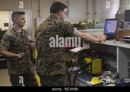 Sgt. Justin W. Ivie, destra e Cpl. Davis E. Steiner, sinistra, calibrare un veicolo automatizzato sistema diagnostico a Camp Kinser, Okinawa, in Giappone il 23 luglio 2018. Per una corretta calibrazione del sistema consente di Marines per identificare correttamente i problemi con i veicoli in tutta la terza Marine Logistics Group. Ivie e Steiner sono misure di test e per apparecchiature di diagnostica con i tecnici di manutenzione elettronica azienda logistica di combattimento del reggimento di 35, 3° MLG. Ivie è un nativo di Oviedo, Florida. Steiner è un nativo di Atlanta, Georgia. Foto Stock