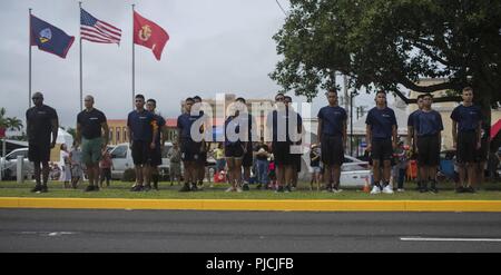 Reclutatori e poolees dal Guam's stazione di reclutamento stand presso l'attenzione come i colori passano da durante il giorno della liberazione Parade, luglio 21, 2018 in Guam. Poiché non vi è una sola stazione di reclutamento nelle isole del Pacifico, poolees hanno per inviare video tramite i social media per mostrare la loro preparazione fisica per diventare un U.S. Marine. Foto Stock