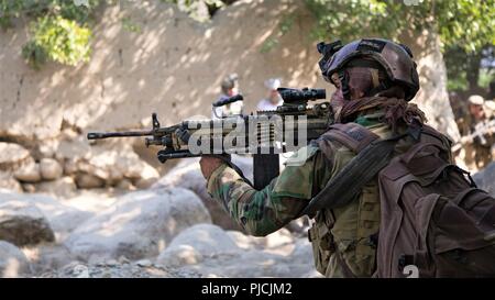 NANGARHAR, Afghanistan (Luglio 22, 2018) - afghane uno speciale delle forze di sicurezza degli stati delle pause durante una pattuglia dopo la conduzione di un raid che ha ucciso il Mullah Nasim Mushfaq, talebani ombra governatore di Kapisa, e Qari Ehsanullah, talebani distretto governatore ombra di Tagab, luglio 22, 2018. (NATO Foto Stock