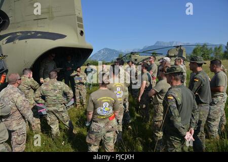 Stati Uniti Paracadutisti dell'esercito assegnato a 173rd Brigata Aerea, insieme con un inglese, francese, spagnolo e italiano paracadutisti, durante un briefing prima di condurre una multinazionale airborne formazione a Giulietta nella zona di caduta, Aviano, Italia, Luglio 19, 2018. La combinazione di esercizio mostra la multinazionale la capacità di costruzione della comunità aerodispersi e focalizzata sul miglioramento della NATO gli standard operativi e di sviluppo delle singole competenze tecniche Foto Stock