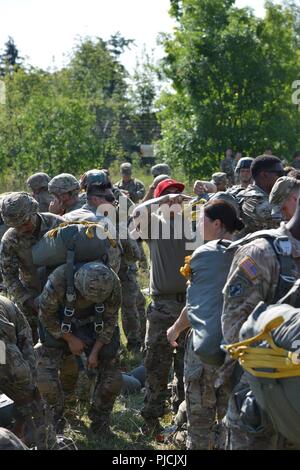 Stati Uniti Paracadutisti dell'esercito assegnato a 173rd Brigata Aerea, insieme con un inglese, francese, spagnolo e italiano paracadutisti, controllare i paracadute durante un operazione di aerei a Giulietta Drop Zone di Pordenone, Aviano, Italia, Luglio 19, 2018. La combinazione di esercizio mostra la multinazionale la capacità di costruzione della comunità aerodispersi e focalizzata sul miglioramento della NATO gli standard operativi e di sviluppo delle singole competenze tecniche Foto Stock