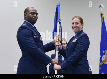 Stati Uniti Air Force Col. Leo Lawson, Jr., 81st gruppo Formazione commander, passa il 336a Training Squadron guidon per il Mag. Jill Heliker, 336a TRS commander, durante la 336a TRS modifica del comando cerimonia nella Roberts ha consolidato la manutenzione di aeromobili struttura presso Keesler Air Force Base, Mississippi, luglio 23, 2018. Il passaggio del guidon è un simbolo di cerimoniale di scambiare il comando da un comandante di un'altra. Foto Stock