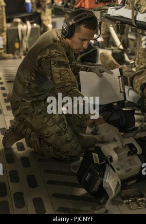 Senior Airman Eric Mukes, volo medic, 455th Expeditionary evacuazione di medicina aeronautica Squadron (EAES), Bagram Airfield, Afghanistan, controlli di un paziente con segni vitali di un paziente il monitor vitali durante un controllo periodico in rotta di Ramstein Air Base, Germania, 21 luglio 2018. Il avieri del 455th EAES sono tasked con il trasporto di feriti negli Stati Uniti e la NATO partner membri del servizio di assistenza a lungo termine di impianti di trattamento. Foto Stock