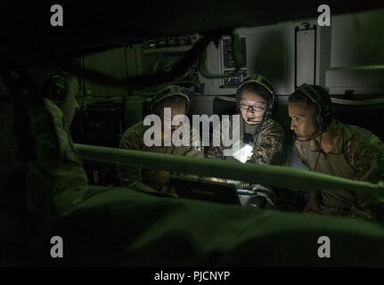 Avieri dal 455th Expeditionary evacuazione di medicina aeronautica Squadron, Bagram Airfield, Afghanistan, grafico segni vitali del paziente come gli Stati Uniti e la NATO pazienti di dormire durante il volo a bordo di una C-17 Globemaster III legata a Ramstein Air Base, Germania, 21 luglio 2018. Questi aviatori hanno il compito di trasportare feriti NEGLI STATI UNITI E LA NATO partner membri del servizio. Foto Stock