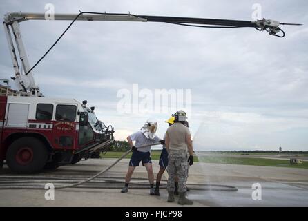 Stati Uniti Air Force Protezione Antincendio avieri con il sesto ingegnere civile Squadron assistere i cadetti di operare una manichetta antincendio al momento del crash la stazione dei vigili del fuoco a MacDill Air Force Base Fla., Luglio 6, 2018. Stati Uniti Air Force Academy e ufficiale della riserva la formazione Corps cadetti girato MacDill come parte delle operazioni di Air Force programma. Il programma di due settimane dà visitando i cadetti di esperienze e conoscenze attraverso attività e visite guidate di strutture di base. Foto Stock