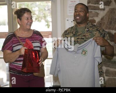 Il colonnello Sekou S. Karega, in uscita ufficiale in comando, è tutto sorrisi dopo la ricezione di una T-shirt da Erin Foster, Base Comptroller, a nome di tutta la S-8 Comptroller reparto come un andare lontano regalo durante una grandine e addio al magg. Gen James L. Conference Center a bordo MCLB Barstow, 18 luglio. Foto Stock