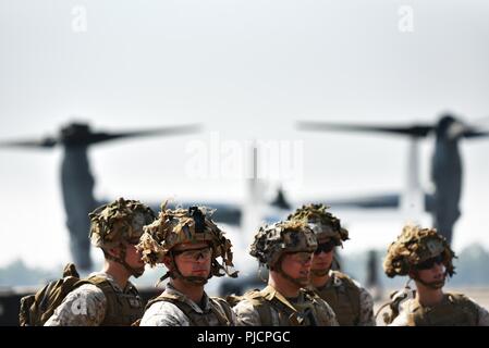 Marines con Marine forza rotazionale - Darwin 18 preparare a bordo di una MV-22 Osprey tilt-rotore aeromobili alla Royal Australian Air Force Base di Darwin Luglio 24, 2018. I marines si stavano dirigendo verso il Monte Bundy a prendere parte nel campo della formazione. MRF-D serve come un Marine Air Ground Task Force che consente di Marines e l'Australian Defence Force per combinare la formazione e migliorare l'interoperabilità tra le forze. Foto Stock