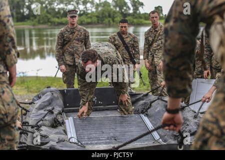 Stati Uniti Marine Cpl. Braxton Shrader, un ingegnere di combattimento con ponte Company, 7 Supporto tecnico di battaglione, Marittima 1 Logistics Group, mostra Marines con ponte Company, 6 ESB, 4 MLG, come disimballare e costruire una lotta contro la razzia di gomma artigianato per essere usato come una barca di sicurezza a Fort Chaffee, arca. Luglio 16, 2018. Durante il fiume Assault 2018, Marines dal sesto e settimo ESB ha avuto la possibilità di condividere esperienze e conoscenze da lavorare mano nella mano conducendo operazioni di rafting sul fiume Arkansas. Foto Stock