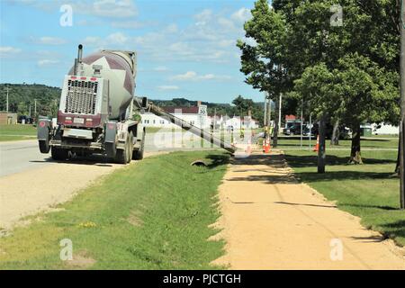 I contraenti a lavorare su un nuovo marciapiede 24 luglio 2018, sull'area di Cantonment a Fort McCoy, Wis. Fort McCoy della Direzione dei Lavori pubblici coordinati all'inizio dell'anno per il lavoro sul marciapiede per essere completata tra il 1100 e il 1400 blocchi sul area di cantonment. Allcon Costruzione di Milwaukee completato l'opera. Foto Stock