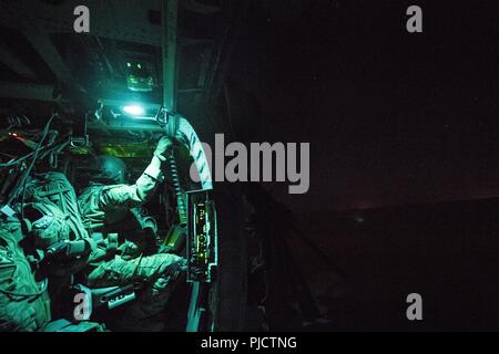 Un U.S. Air Force speciale missione aviatore assegnato alla quarantaseiesima Expeditionary squadrone di salvataggio si siede a bordo di un HH-60G Pavehawk durante una missione in Iraq, 18 luglio 2018. La missione primaria di HH-60G Pave Hawk elicottero è di condurre di giorno o di notte personale le operazioni di ripristino in ambienti ostili per recuperare personale isolato durante la guerra. Foto Stock