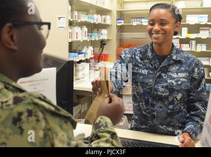 Il Jacksonville, Florida (24 luglio 2018) Hospitalman Denesha Lewis fornisce farmaci da un marinaio al ramo navale Health Clinic di Jacksonville farmacia. Lewis, nativo di Los Angeles, California, dice "Siamo qui per aiutarvi a ottenere una migliore e unisciti alla lotta di nuovo". Foto Stock