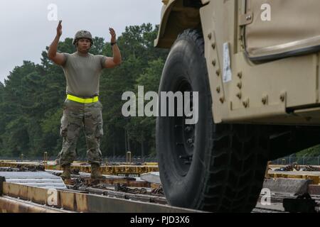 Stati Uniti Paracadutisti dell'esercito assegnato al primo battaglione, campo 319reggimento di artiglieria, 3° Brigata Team di combattimento, ottantaduesima Airborn Division, guida veicoli tattici su vagoni ferroviari selezionati a Fort Bragg railyard durante il primo combattimento vigili del Team, ottantaduesima divisione aerotrasportata di Deployment Readiness esercitare sulla luglio 18, 2018. Il DRE è progettato per testare l'efficacia generale e la disponibilità di unità selezionata quando sono chiamati a distribuire entro una 18-ora periodo. Foto Stock