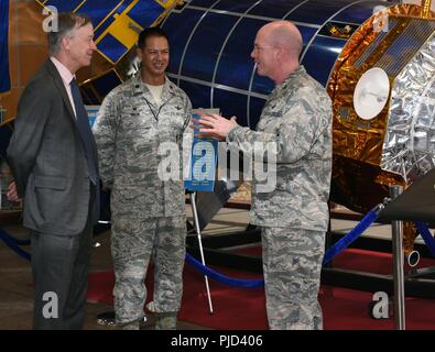 Gov. John Hickenlooper del Colorado, estrema sinistra, riceve un briefing di Col. Troy Endicott, estrema destra, Spazio 460th Wing Commander, e il tenente Col. Michael Kruk, xi di avviso dello spazio comandante dello squadrone, sulla base nello spazio di sistema a infrarossi nella missione della stazione di controllo di lobby presso Buckley Air Force Base in Colorado, luglio 17, 2018. Mentre sulla base, Hickenlooper ha ricevuto un approfondito breve sulla missione funzionalità fornite dal 460th SW, che comporta a livello globale di sorveglianza a infrarossi, il monitoraggio e la segnalazione di missili di teatro e Homeland Defence. Foto Stock