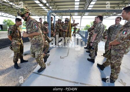 L'Esercito Italiano paracadutisti assegnato alla brigata Folgore, durante la base multinazionale airborne addestramento di aggiornamento al settimo Esercito di formazione del comando di Vicenza, Airborne Refresher Training Facility alla Caserma del Din, Vicenza, Italia, Luglio 18, 2018. La combinazione di esercizio mostra la multinazionale la capacità di costruzione della comunità in volo e il airborne nazioni alleate collettivamente e focalizzata sul miglioramento della NATO gli standard operativi e di sviluppo delle singole competenze tecniche Foto Stock