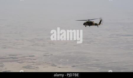 KANDAHAR AIRFIELD, Afghanistan (Luglio 22, 2018) -- Un esercito nazionale afghano aria equipaggio di un UH-60un Black Hawk assegnato alla seconda ala Afghan Air Force a Kandahar Airfield, Afghanistan, esegue una formazione di volo il 22 luglio 2018. I consulenti di aria di assistere i loro omologhi afgano elevazioni e formazioni di volo. Foto Stock