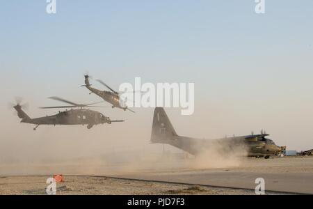 Due HH-60G Pave Hawks forniscono la protezione per un HC-130J Super Hercules assegnato al XXVI Rescue Squadron mentre i superstiti simulata sono caricati dopo uno scenario di addestramento durante un combattimento di ricerca e salvataggio di esercizio in Iraq, 15 luglio, 2018. La HC-130J sostituito HC-130P/Ns come unico dedicato ad ala fissa il personale piattaforma di recupero nella Air Force inventario. La sua missione è quella di distribuire rapidamente per eseguire lottatori commander diretto delle operazioni di recupero di austera gli aerodromi e negato il territorio per expeditionary, tutti personale meteo operazioni di recupero per includere airdrop, airland, elicottero aria-per- Foto Stock