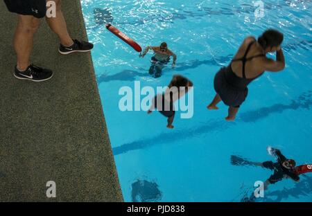 Grandi laghi, Ill. (Luglio 18, 2018) reclute completare un platform saltare durante una terza classe di qualifica nuotare presso la USS Indianapolis piscina al reclutamento di formazione di comando (RTC). Le reclute sono tenuti a superare il criterio in modo da poter graduare a piacere da boot camp include un 10-piede salto di piattaforma, 50 metri nuotata e in cinque minuti un soggetto galleggiante. Circa 38,000-40,000 reclute graduate annualmente da RTC. Foto Stock