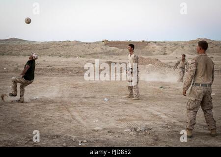 FIREBASE UM JORAIS, IRAQ - STATI UNITI Marines con scopi speciali Air-Ground Marine Task Force, crisi comando Response-Central costruire un cameratismo da giocare a calcio al fuoco Base Jorais Um (FB UJ) Luglio 5, 2018. SPMAGTF-CR-CC Marines assistita nel funzionamento Taloni lancia fornendo una sicurezza a FB UJ. Foto Stock