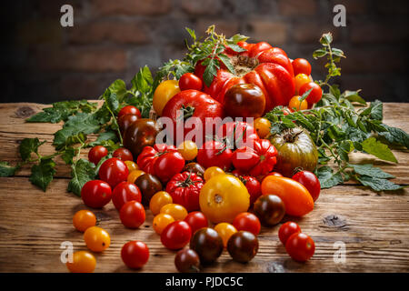 Colorate pomodori organici sulla superficie di legno Foto Stock