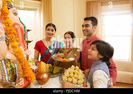 Famiglia Ganpati perfoming aarti sul Ganesh Chaturthi a casa Foto Stock