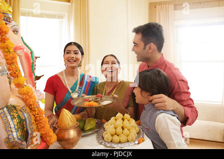 Famiglia Ganpati perfoming aarti sul Ganesh Chaturthi a casa Foto Stock