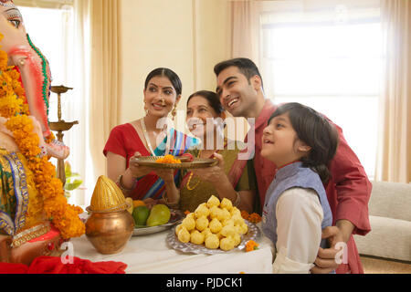 Famiglia Ganpati perfoming aarti sul Ganesh Chaturthi a casa Foto Stock