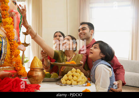 Famiglia Ganpati perfoming aarti sul Ganesh Chaturthi a casa Foto Stock