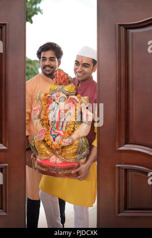 Gli uomini portando Ganpati home in occasione del Ganesh Chaturthi Foto Stock