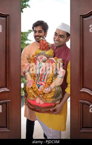 Gli uomini portando Ganpati home in occasione del Ganesh Chaturthi Foto Stock