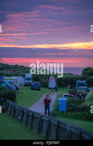 St Ives, Inghilterra - Maggio 2018 : Automobili, tende e persone in un campeggio al tramonto sul Cornish Coast, Cornwall, Regno Unito Foto Stock