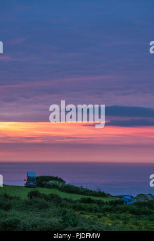 St Ives, Inghilterra - Maggio 2018 : Automobili, tende e persone in un campeggio al tramonto sul Cornish Coast, Cornwall, Regno Unito Foto Stock