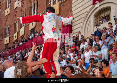 Il cavallo vincente e Jockey da la Giraffa Contrada celebrare la vittoria in Piazza del Campo Palio di Siena, Siena, Italia Foto Stock