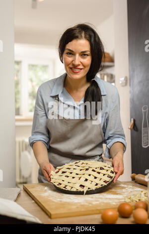 Donna che mantiene la torta dolce nelle sue mani Foto Stock