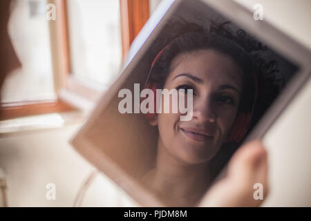 Immagine del volto di donna con le cuffie sulla tavoletta digitale Foto Stock