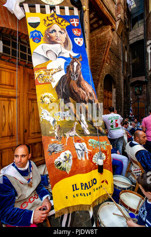 I membri della vittoriosa Istrice Contrada prendere un periodo di riposo  come essi sfilano per il premio di un banner di seta in giro per le strade di  Siena, il Palio di