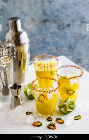 Cocktail margarita di tequila, succo di mango, peperoncino e lime sul tavolo. accessori bar Foto Stock
