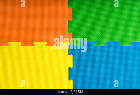 Schiuma di piastrelle di pavimentazione / stuoie all'interno di una sala giochi, kindergarten scuola o palestra. Uso potenziale come uno sfondo colorato con copia spazio. Foto Stock