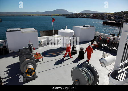 Il pianale posteriore della nave traghetto Hamnavoe lasciando il porto di Stromness, isole Orcadi, le colline di Hoy a distanza Foto Stock