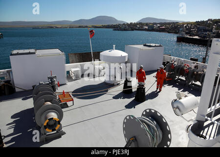 Il pianale posteriore della nave traghetto Hamnavoe lasciando il porto di Stromness, isole Orcadi, le colline di Hoy a distanza Foto Stock