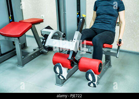 Giovane donna gamba fa esercizi in palestra Foto Stock