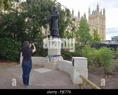 Una donna scatta una foto della statua del leader delle suffragette Emmeline Pankhurst, che ha giocato un ruolo importante nella campagna per fissare la votazione per le donne, come Shadow Commons leader Valerie Vaz ha incoraggiato il supporto per la campagna di tenere il memorial nella torre di Victoria Gardens, che confinano con il Palazzo di Westminster a Londra centrale. Foto Stock