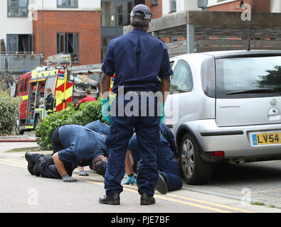 Gli ufficiali di polizia effettuare una ricerca dopo un incendio scoppiato nelle prime ore del mattino, dove una donna è morta in Piazza Centurion, Sud-est di Londra. Foto Stock