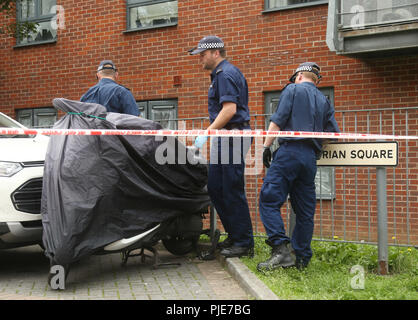 Gli ufficiali di polizia effettuare una ricerca dopo un incendio scoppiato nelle prime ore del mattino, dove una donna è morta in Piazza Centurion, Sud-est di Londra. Foto Stock