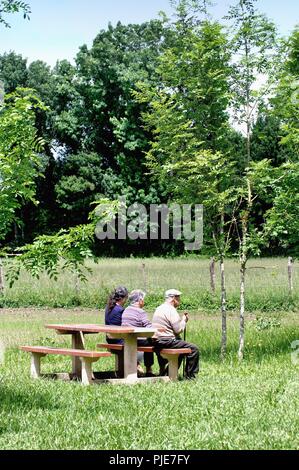 Tre persone anziane seduta sul banco nella campagna francese nei pressi di Mansle, Charente Poitou sud ovest della Francia UE Foto Stock