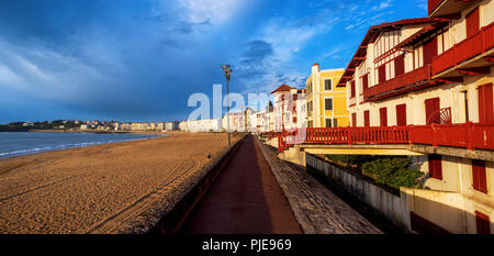 Tradizionale basca colorate case di legno rivolta verso la spiaggia in sabbia di St Jean de Luz, Oceano Atlantico costa, Francia Foto Stock