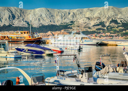 Una vasta gamma di barche ancorate sul mare Adriatico cittadina portuale di Baska, sull'Isola di Krk in Croazia Foto Stock