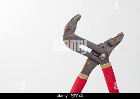 Vecchio arrugginito pinze per tubo rosso con maniglie in gomma Foto Stock