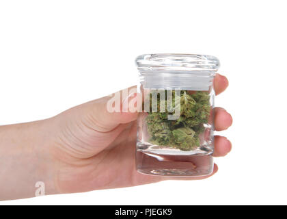 Giovani femmine mano che tiene il vasetto di vetro con freschi boccioli di marijuana. Una sostanza psicoattiva dalla pianta di cannabis usata per uso medico o per finalità ricreative. Foto Stock